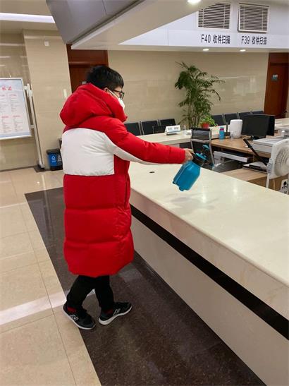 不动产登记中心值班人员在对窗口桌面进行消毒。